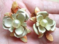 Front view showing enamel roses, faux pearl centers, leaf accents