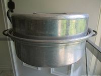 Side view of aluminum pot with lid showing handles