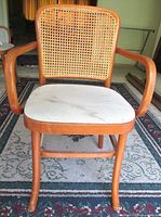 Front view showing entire chair frame, cane backrest, arms and seat