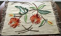 Full view of pillow sham showing Jacobean floral embroidery and fringe