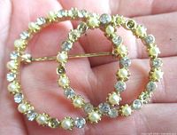 Front view showing faux pearls and rhinestones in interlocking circles