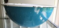 side view showing teal speckled exterior and rolled rim
