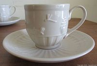 Cup on saucer, showing handle and relief motifs
