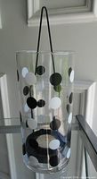 Front view of glass hurricane holder with polka dots and metal handle