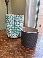 Teal patterned and grey diamond ceramic planters on table