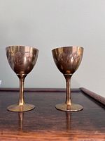 Front view of both etched brass cups standing side by side