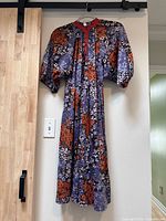Full front view of floral dress on hanger showing overall design and length