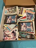 Open cardboard box filled with stacks of loose baseball cards