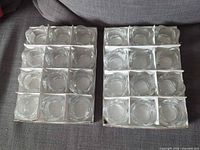 Two trays holding 24 clear glass candle holders