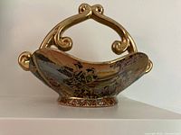 Front view showing painted geisha scene and gold handle