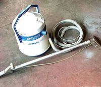 Extractor with hose and wand laid out on floor