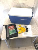 Group shot showing cooler, air pump, table cover, bag and paperwork