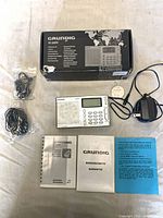 Complete lot: radio, AC adapter, earbuds, paperwork, box