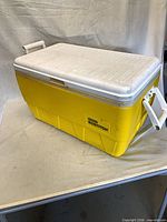 Three-quarter view of yellow Igloo cooler with white lid and Stanley/Bostitch sticker
