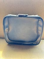 Front view of black carry-on suitcase with external pocket