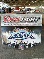Front of metal sign showing Coors Light logo, Official Beer Sponsor text, Super Bowl XXXIX emblem, silhouettes and NFL shield
