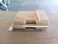 Closed beige Fisher-Price record player showing carry case and frayed AC cord