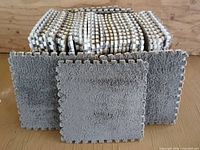 stack of gray interlocking carpet/foam tiles showing puzzle edges and surface texture