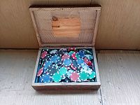 Open wooden box filled with mixed color poker chips