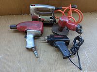 Group shot of four tools: jigsaw, pneumatic impact, soldering gun, polisher