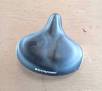 Top rear view of Schwinn black wide saddle showing logo and overall shape