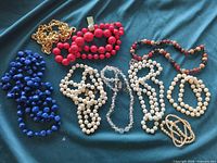 All eight necklaces laid out on fabric