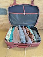 Open red suitcase showing interior lining and folded fabrics