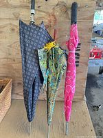 Three closed umbrellas showing patterns and handles