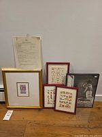 All framed artworks and certificate grouped together against wall