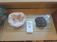 Quartz geode half and botryoidal hematite on glass tray overview