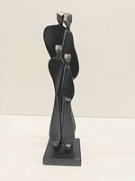 Front view of black metal abstract family sculpture on square base