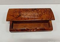 Closed burl wood box showing lid grain and front cutout