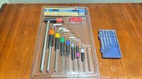 Front view of sealed Powerfist hex wrench set next to blue case bit set