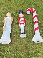 Angel, toy soldier and candy cane blow molds on grass