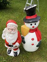 Snowman and Santa full view standing on grass