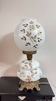 Full view of lamp unlit showing painted globes and metal base