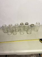 ten assorted mason jars on table with tape measure for scale