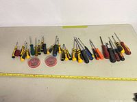 Full lot layout showing all screwdrivers and bit holders with measuring tape for scale