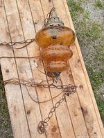 Full lamp on table showing glass body, chain and cord