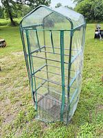full view of mini greenhouse showing frame, shelves and PVC cover