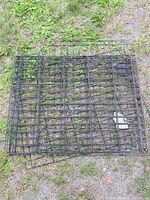 folded black metal wire dog crate on ground
