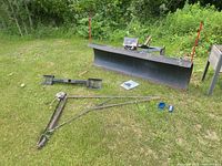Overall view of snowplow blade, A-frame tongue, brackets and accessories on grass