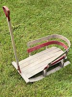 Top view of wooden sled showing deck, side rails, and pull handle