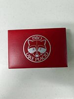Top view of red box showing silver 1980 Lake Placid raccoon logo