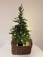 Front view of artificial tree with lights in basket