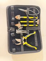 Open case showing six garden tools secured inside
