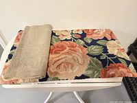 Floral accent rug folded on table showing pile and pattern