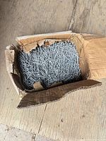 Open box showing large quantity of galvanized nails