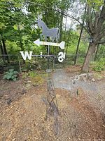 Full view of weather vane on tower in outdoor setting
