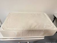 Top view of closed white fabric storage box showing size and zippered lid